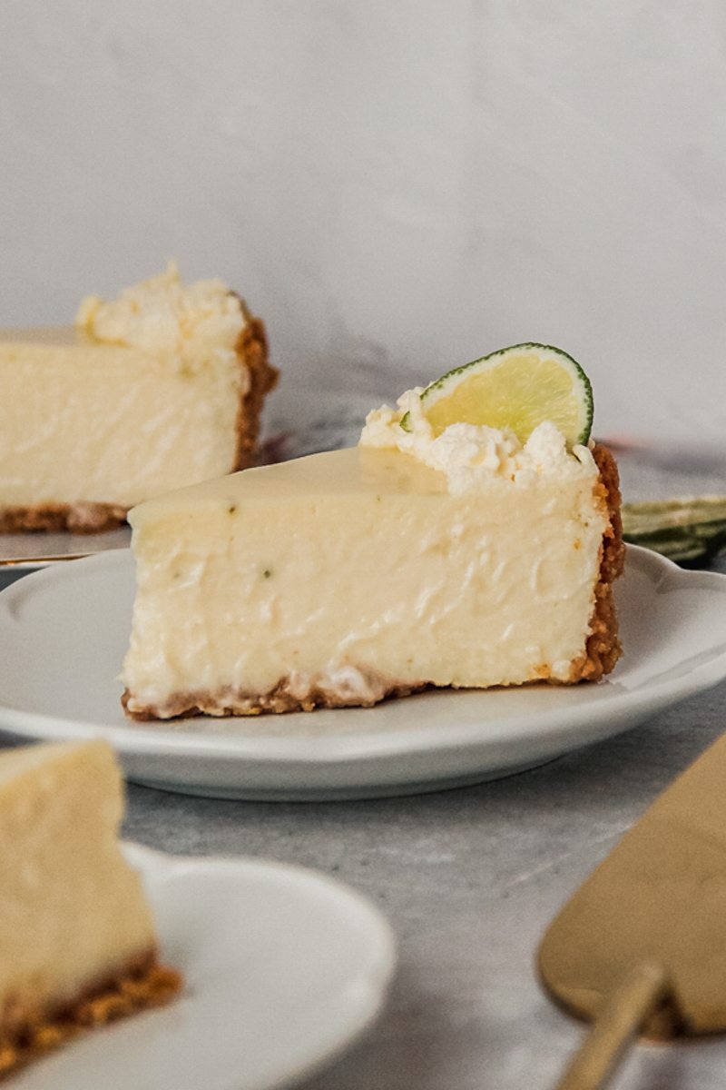 A slice of creamy no baked key lime cheesecake sits on an individual plate.