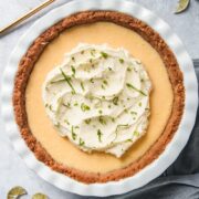 Key Lime Pie sits in a white ceramic pie plate on a gray surface.