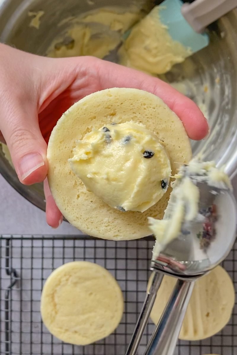 Passionfruit frosting is placed in the middle of a melting moment biscuit before being sandwiched between another biscuit.