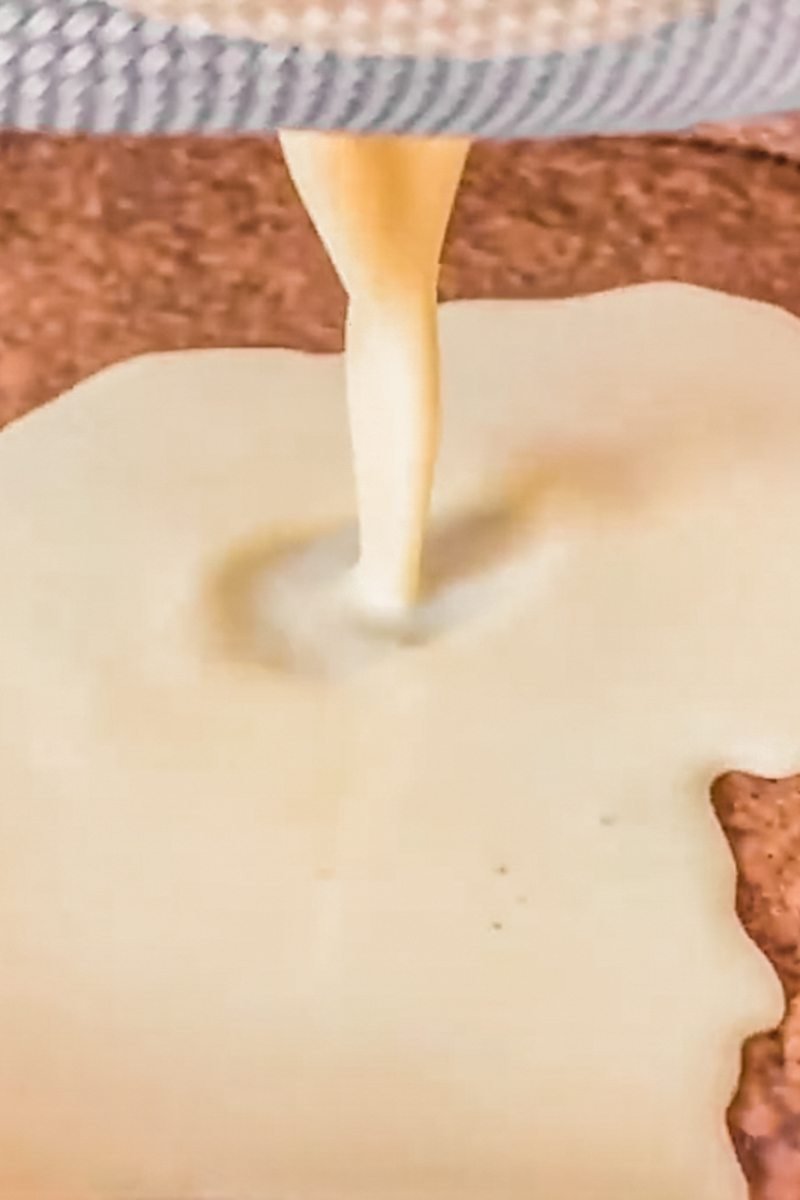 Custard is strained into a baked crushed biscuit base.