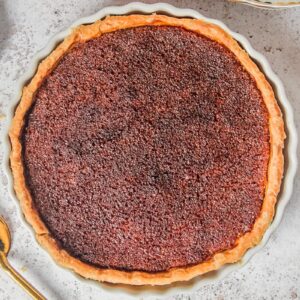 Treacle tart sits on a light gray surface.