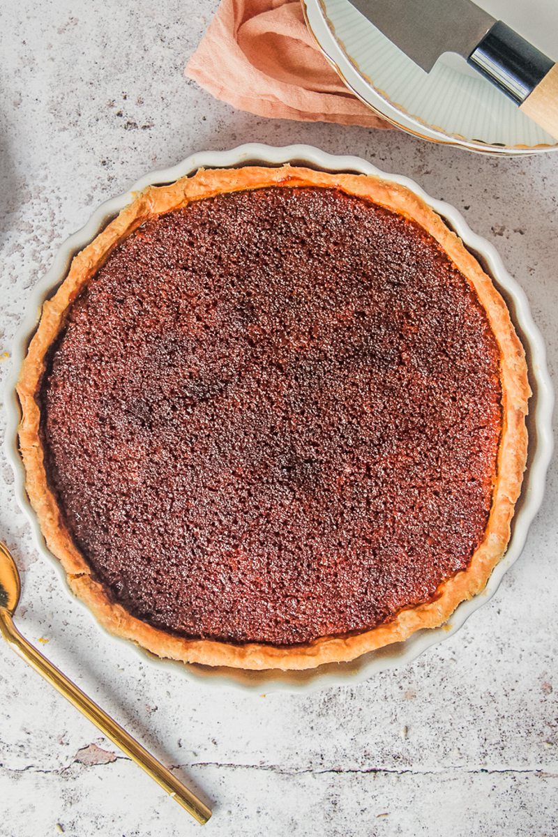 Treacle tart sits on a light gray surface.