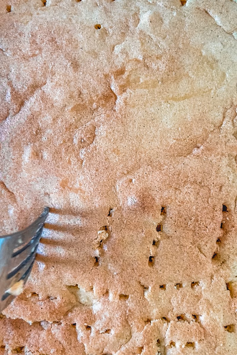 Holes are poked into a Tres Leches cake.